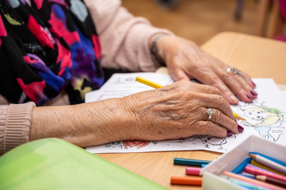 A senior woman doing a coloring page