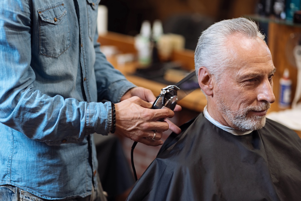 A senior man getting his hair cut at a salon