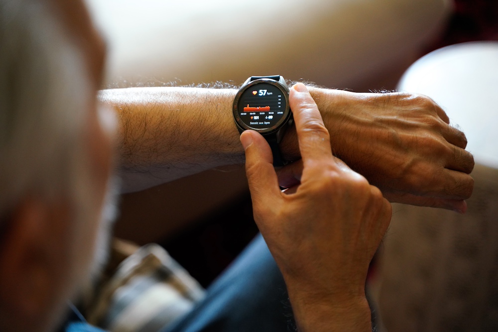 A resident of the senior living in Glendale, CA using his smartwatch to monitor his heart rate